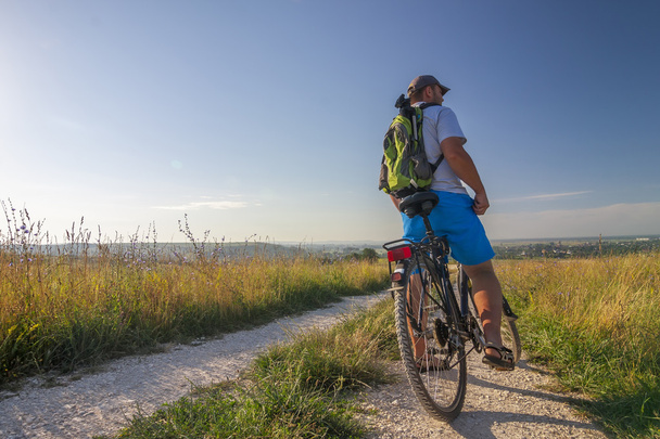 Молодий чоловік подорожує на велосипеді вранці схід сонця з чудовим
 - Фото, зображення