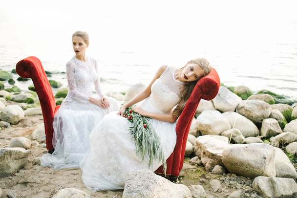 Twin sisters in wedding dress on the seashore - Foto, afbeelding