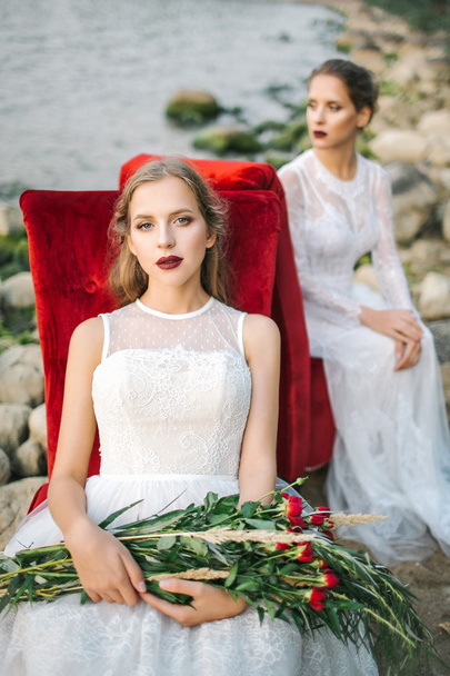 Twin sisters in wedding dress on the seashore - Fotó, kép