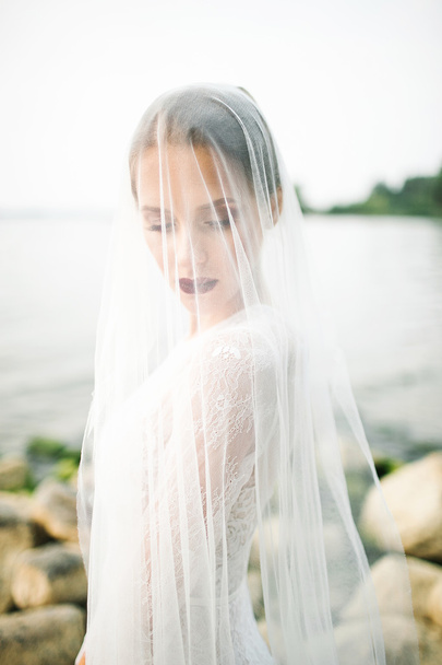 Young beautiful bride in wedding dress near sea - Foto, Imagem