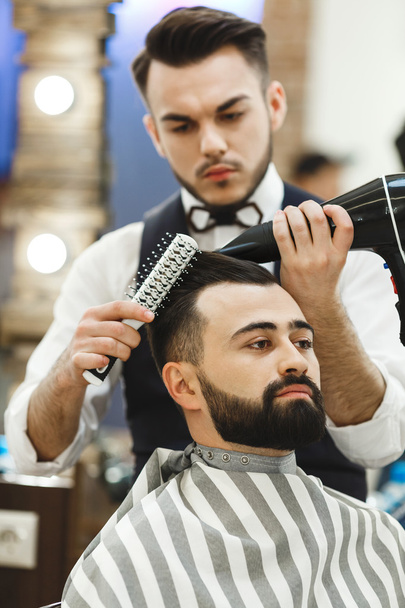 Dark haired barber doing a haircut - Foto, Bild