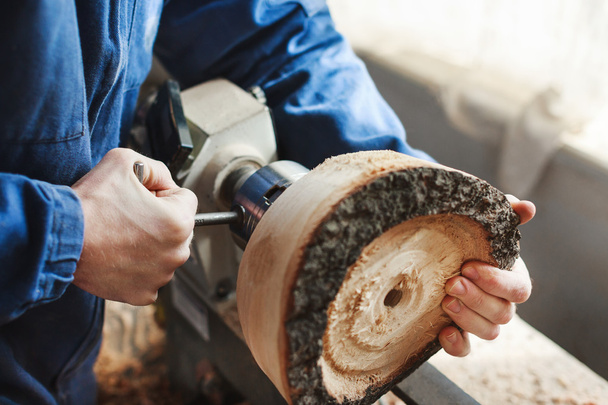 Een man die werkt met houtsnijwerk instrumenten - Foto, afbeelding