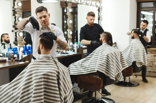 Homens na barbearia a fazer cortes de cabelo
 - Foto, Imagem