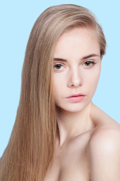 beautiful young woman face over blue background - Fotó, kép