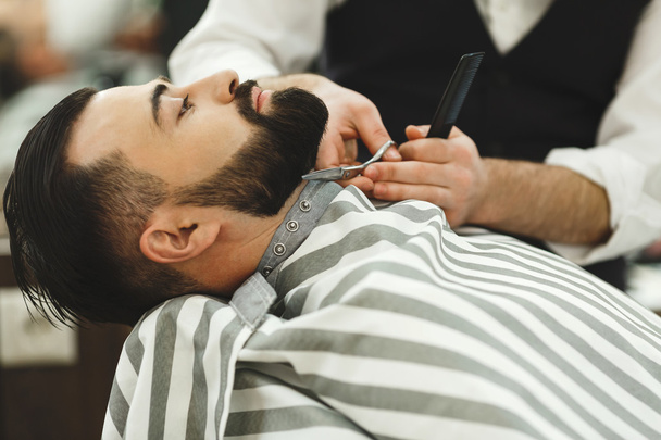 Barbeiro fazendo uma barba
 - Foto, Imagem