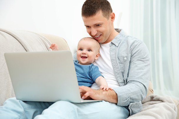 Father holding baby and working - Zdjęcie, obraz