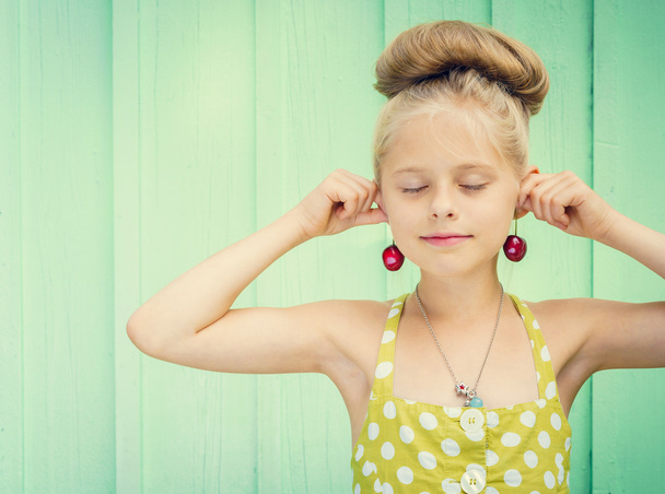 Beautiful girl holding cherries as earrings -style Rockabilly. - Photo, Image