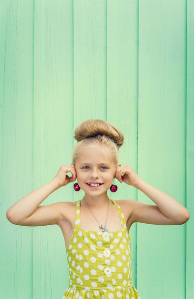 Beautiful girl holding cherries as earrings -style Rockabilly. - Photo, Image