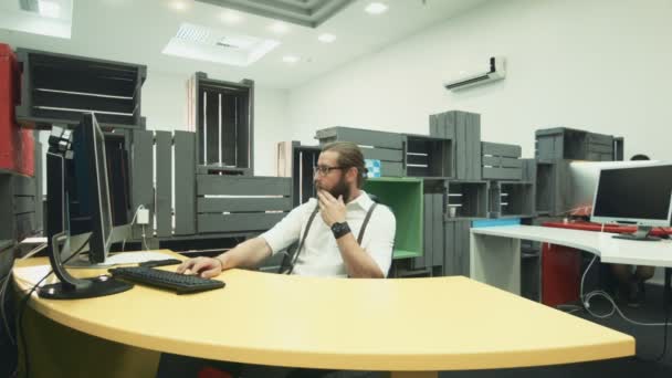 Mann arbeitet am Computer und spricht mit seinem Kollegen mit Tablet - Filmmaterial, Video
