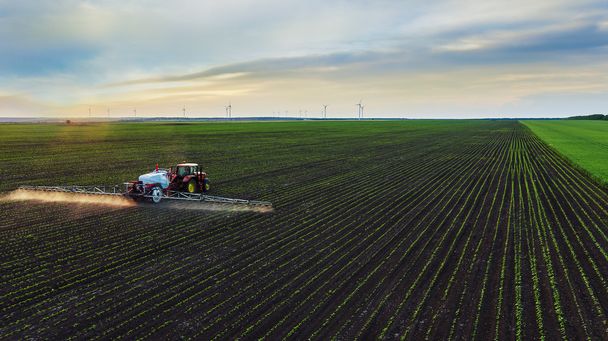 Traktor sprüht Feld im Frühling  - Foto, Bild