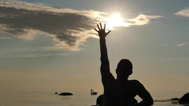 Valehtelee menettää vahvuus mies koskettaa aurinkoa viime elämän minuuttia hidastettuna - siluetti
 - Materiaali, video