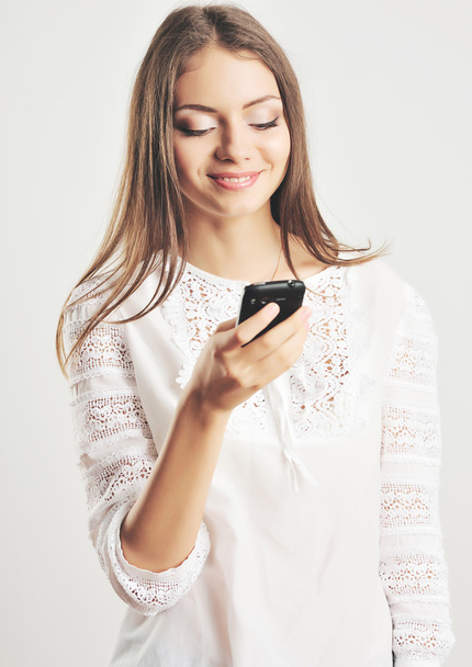 スマート携帯電話でメッセージを読んで若い美しい女性 - 写真・画像