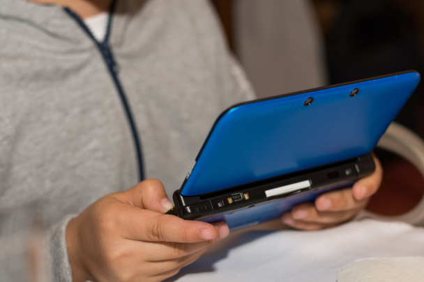 Child playing with portable games console - Photo, Image