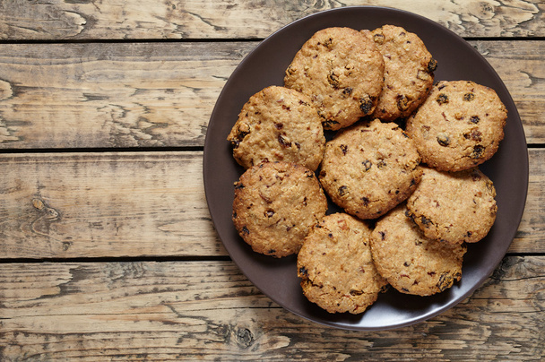 Biscoitos caseiros de aveia de cereais com passas e sobremesa doce saudável de chocolate
 - Foto, Imagem
