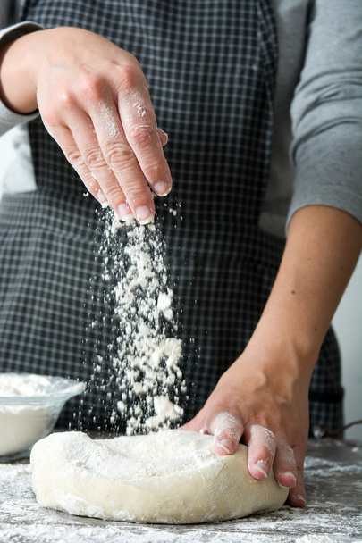 Kadın elleriyle ekmek hamuru yoğuruyor. - Fotoğraf, Görsel