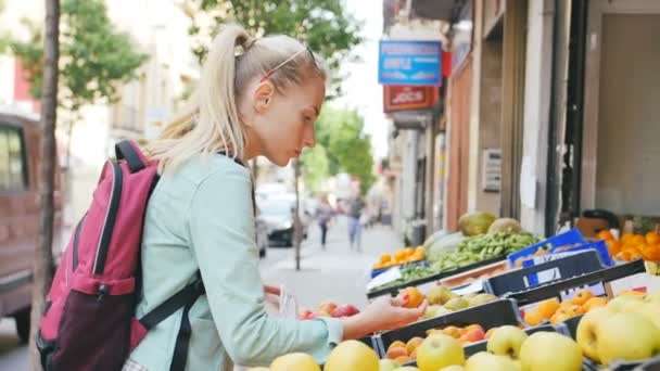 Γυναίκα εξέταση φρούτα στο στη λαϊκή αγορά - Πλάνα, βίντεο