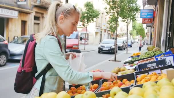 Γυναίκα εξέταση φρούτα στο στη λαϊκή αγορά - Πλάνα, βίντεο