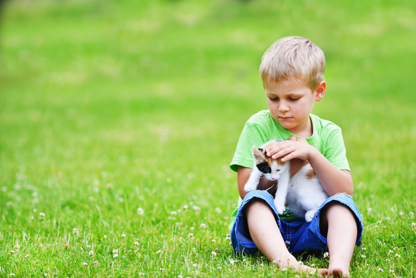斑点を付けられた猫と遊ぶ少年  - 写真・画像