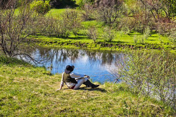 man sits near the river - Foto, Bild