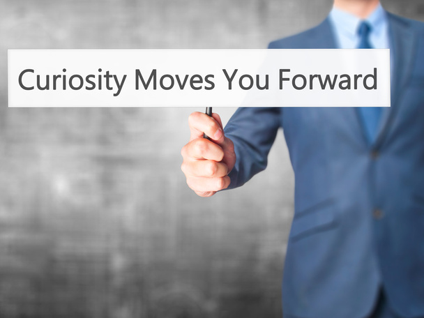 Curiosity Moves You Forward - Businessman hand holding sign - Photo, Image