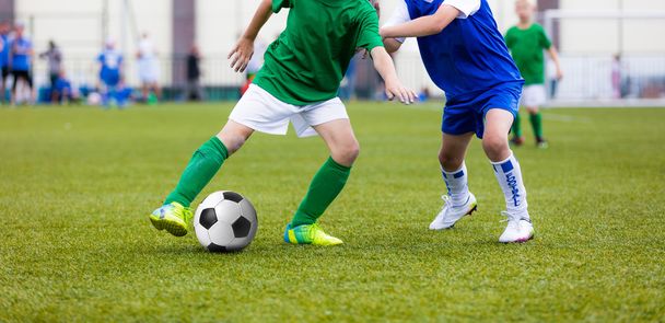 スポーツ フィールドでサッカーの試合サッカーの若い男の子。スポーツ シャツでサッカー選手を実行します。子供たちを実行し、サッカー ボールを蹴る. - 写真・画像