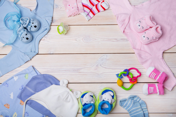 newborn baby clothes on wooden background - Фото, изображение