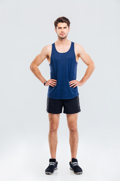 Full length portrait of sportsman standing with hands on hips - Photo, Image