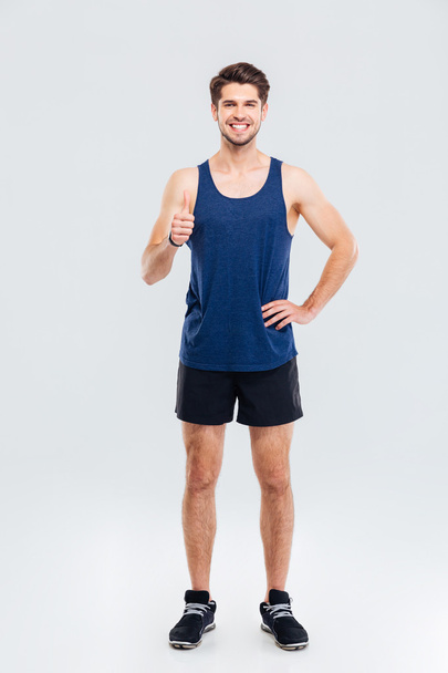 Full length portrait of a fitness man showing thumb up - Photo, Image