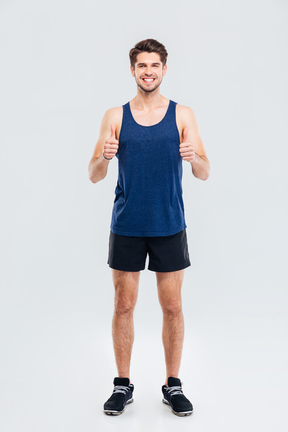 Full length portrait of a fitness man showing thumb up - Foto, imagen