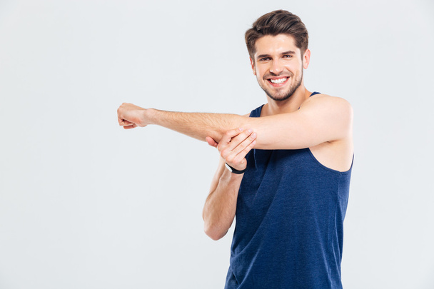 Happy cheerful sportsman doing stretching exercises - Foto, immagini