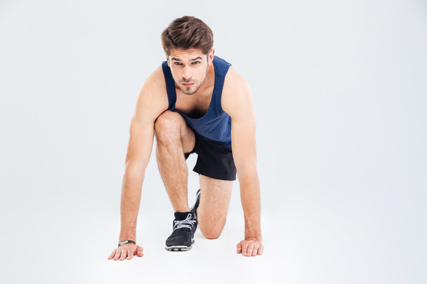 Attractive focused young sportsman ready to start running - Foto, Imagen