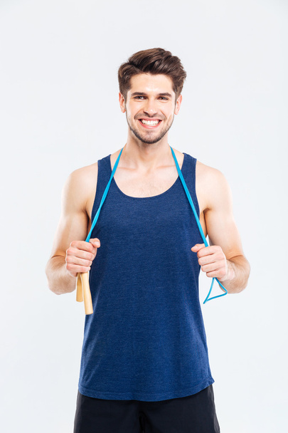 Smiling young male athlete standing and holding skipping rope - Photo, image