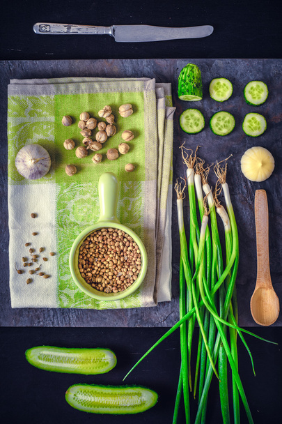 Green vegetables with seasoning on the dark stone background vertical - Photo, image