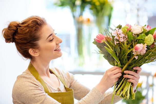 smiling florist woman making bunch at flower shop - Foto, immagini