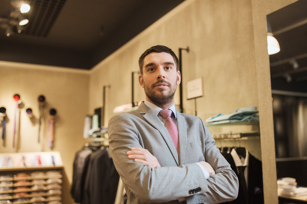 young man or businessman in suit at clothing store - Фото, изображение