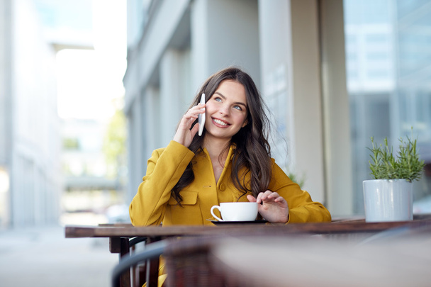 happy woman calling on smartphone at city cafe - Foto, imagen