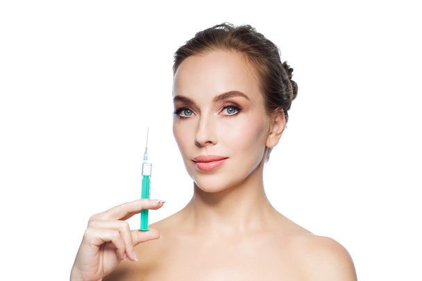 beautiful woman holding syringe with injection - Foto, Imagen