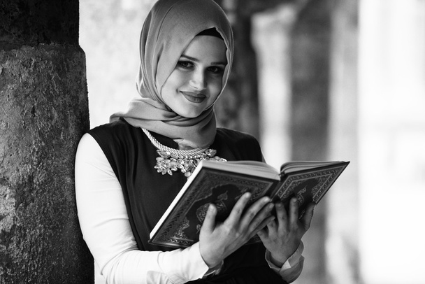 Nuori musliminainen lukeminen pyhä islamilainen kirja Koraani
 - Valokuva, kuva
