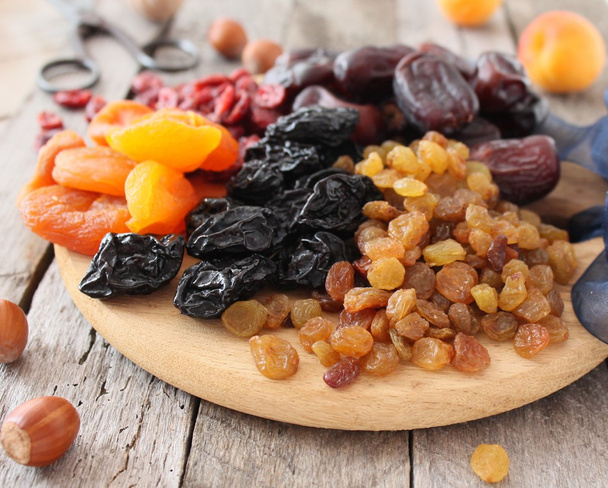 Abricots secs, dattes, raisins secs, fond bois vintage, mise au point sélective
 - Photo, image