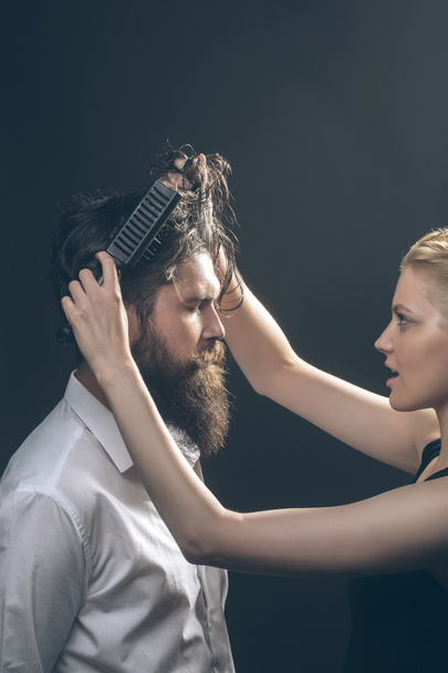 blonde hairdresser combing bearded man - Foto, Bild
