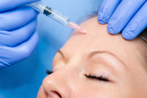 Botox inyectable en la frente de la mujer
 - Foto, imagen