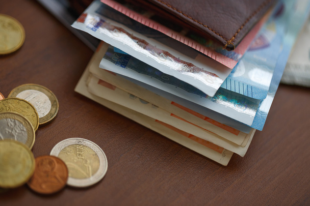 Καφέ πορτοφόλι με χρήματα ευρώ μέσα και κέρματα, πιστωτικές κάρτες, κοντά - Φωτογραφία, εικόνα
