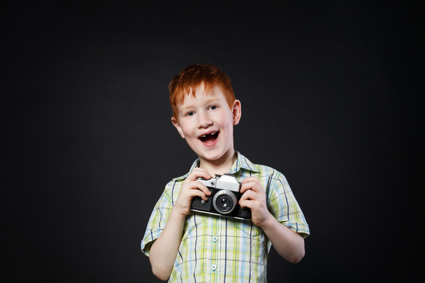 Little boy take photo with vintage camera at black background - Photo, Image
