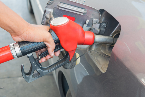 Red Fuel nozzle to release fuel into car at gas station and cont - Photo, Image