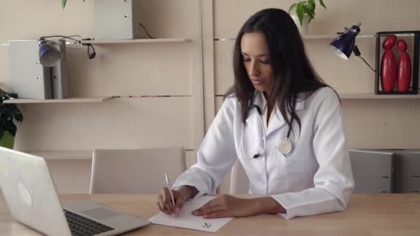 Doctor writing prescription check information on the computer. - Кадры, видео