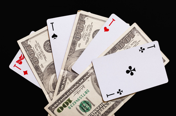 Spielkarten und Hundert-Dollar-Scheine auf schwarzem Hintergrund. - Foto, Bild