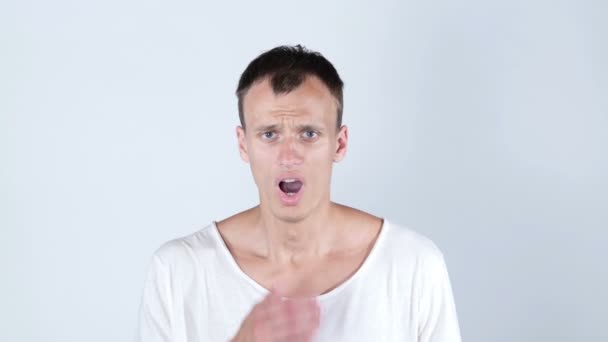 Потрясенный удивленный ошеломленный молодой человек в белой футболке, белый фон
 - Кадры, видео