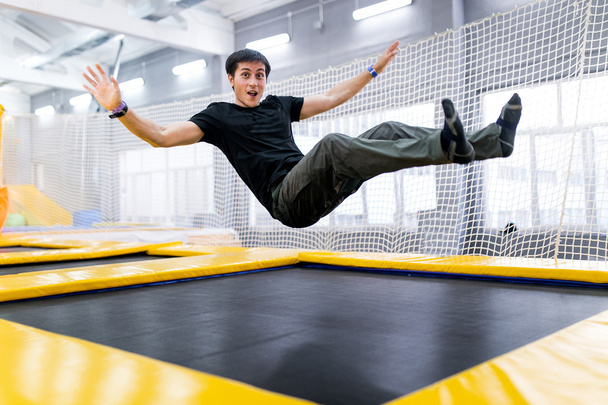 Un jeune homme trampolinant dans un parc à mouches
 - Photo, image