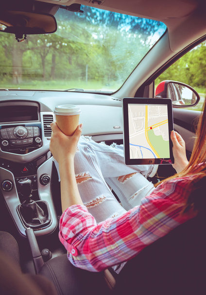 Girl with tablet in her hands in the car - Foto, imagen