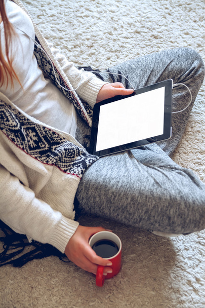 Mulher sentada no sofá com tablet e café na mão
 - Foto, Imagem